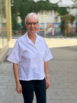 Frau trägt die weiße Baumwollbluse LENI von lackenau über dunkler Jeans, Vorderansicht