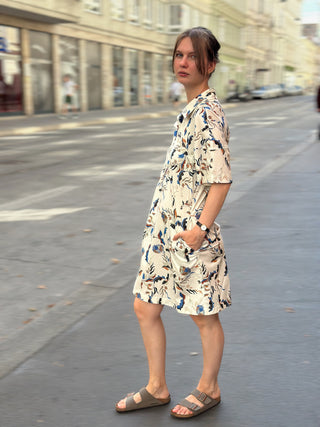 Kleid ELENA cremeweiß floral von der Seite, Hand in der versteckten Seitentasche