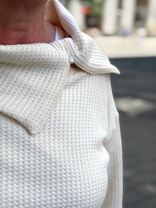 Nahaufnahme von Kragen und Waffeloptik des Pullovers HERBSTA cremeweiß