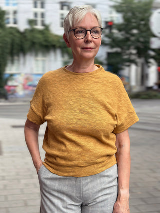 Frau trägt den ockerfarbenen Strickpullover KORRI von lackenau, Vorderansicht