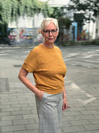Ockerfarbener Pullover KORRI zur hellen Hose, seitliche Ansicht